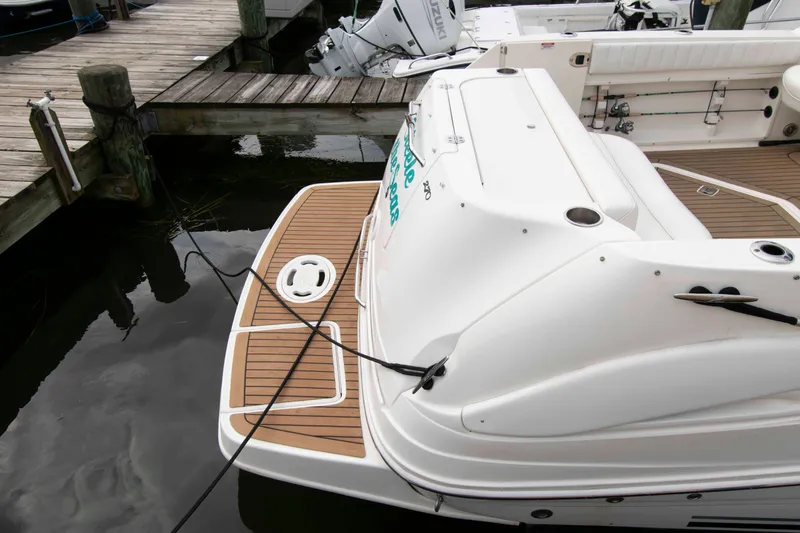Slide: The Image of 2007 Sea Ray 270 Amberjack boat docked, featuring a spacious swim platform. - 3
