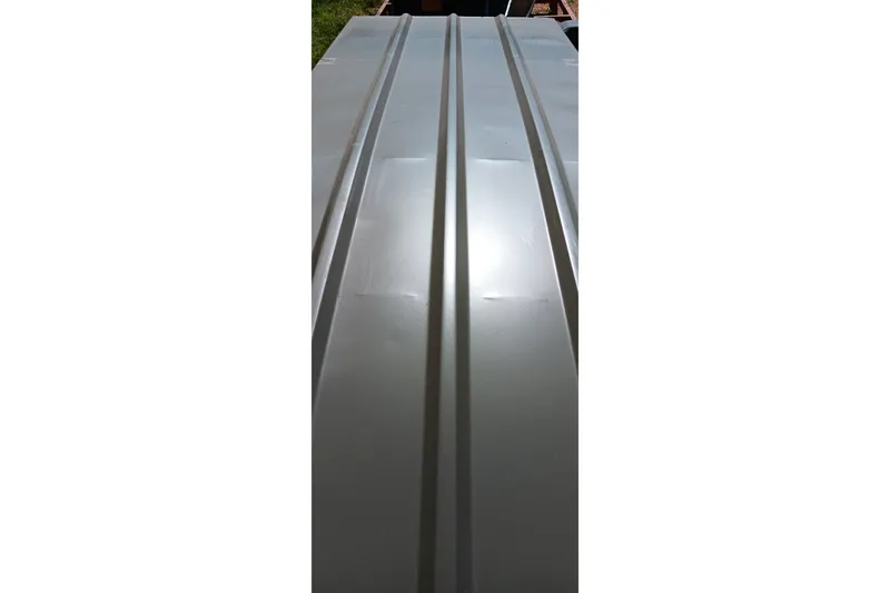 Slide: The Image of 2026 Tracker Grizzly 10 Jon boat hull, showcasing sleek metallic design. - 3