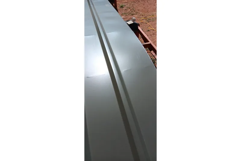 Slide: The Image of Close-up of 2026 Tracker Grizzly 10 Jon boat's sleek, metallic surface under sunlight. - 2