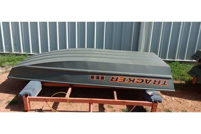 The Image of 2026 Tracker Grizzly 10 Jon boat upside down on a wooden stand outdoors. - 0