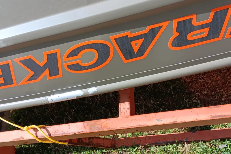 Slide: The Image of 2026 Tracker Grizzly 10 Jon boat on orange trailer, close-up view. - 4