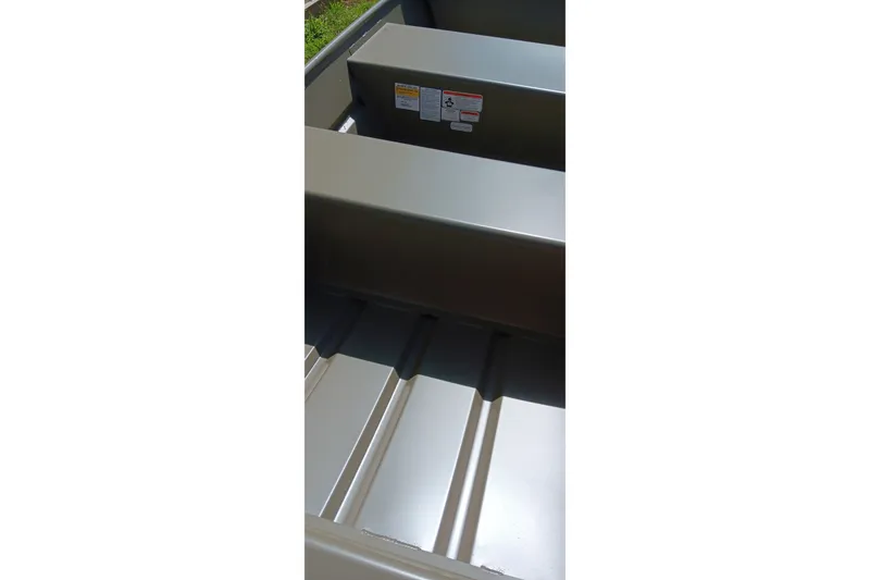 Slide: The Image of Interior view of 2026 Tracker Grizzly 10 Jon boat, showcasing seating and metal flooring. - 10