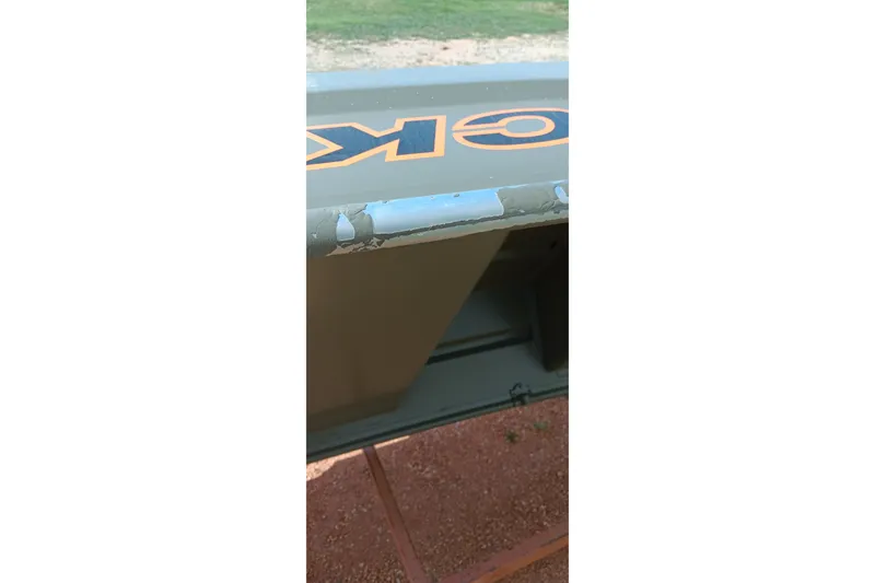 Slide: The Image of 2026 Tracker Grizzly 10 Jon boat with visible paint wear on the edge. - 6