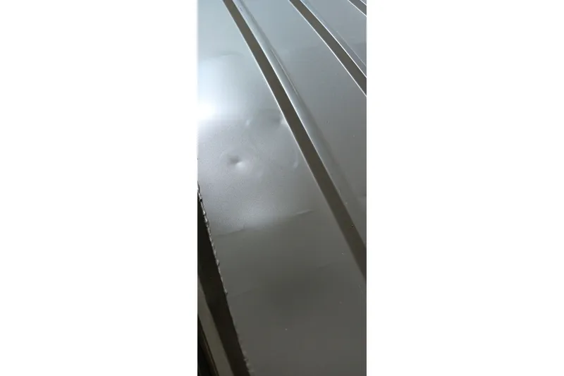 Slide: The Image of Close-up of 2026 Tracker Grizzly 1436 Jon boat surface with visible dents. - 3