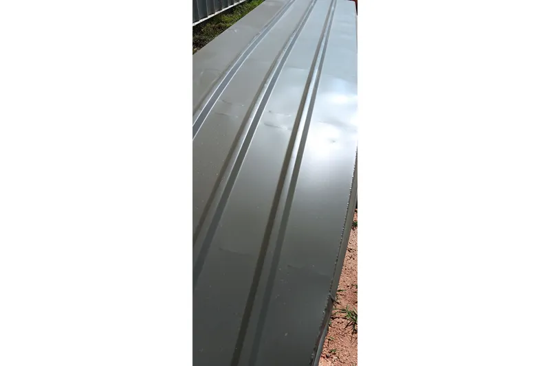 Slide: The Image of 2026 Tracker Grizzly 1436 Jon boat hull, showcasing sleek metallic surface. - 2