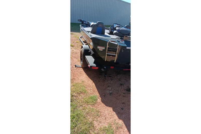 Slide: The Image of 2026 Ranger RT198P boat rear view on gravel, showcasing trailer and ladder. - 3