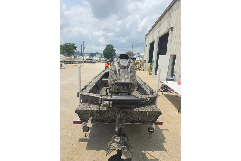 Slide: The Image of Camouflage-patterned 2026 Pro Drive 2054 X Series TD CC boat parked outside a workshop. - 3