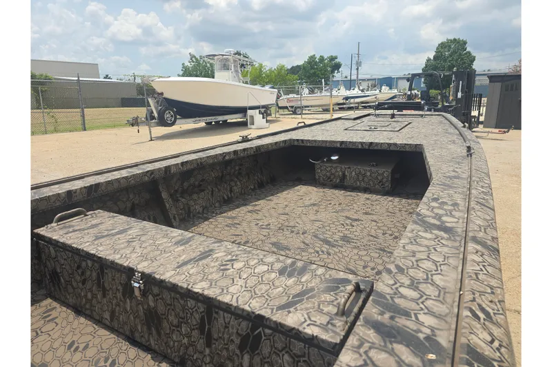 Slide: The Image of Pro Drive 2054 X Series TD CC boat, 2026 model, with camouflage pattern, parked outdoors. - 6