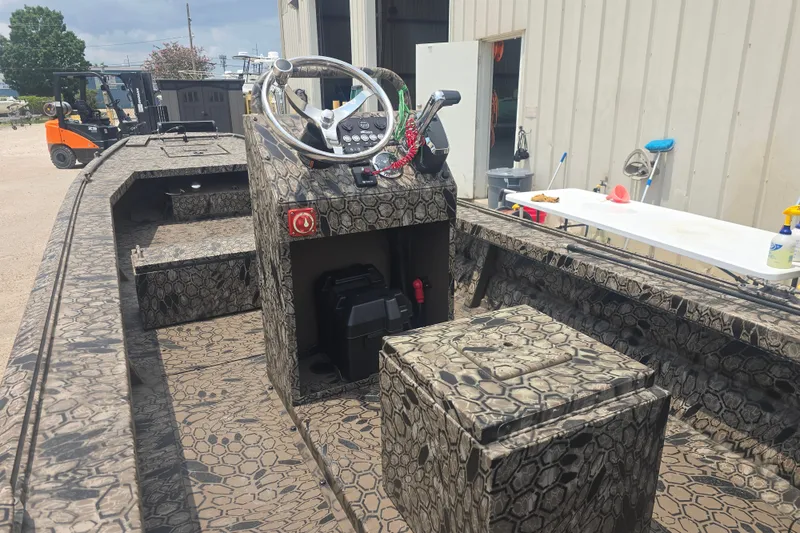 Slide: The Image of 2026 Pro Drive 2054 X Series TD CC boat with camouflage design, parked outdoors. - 8