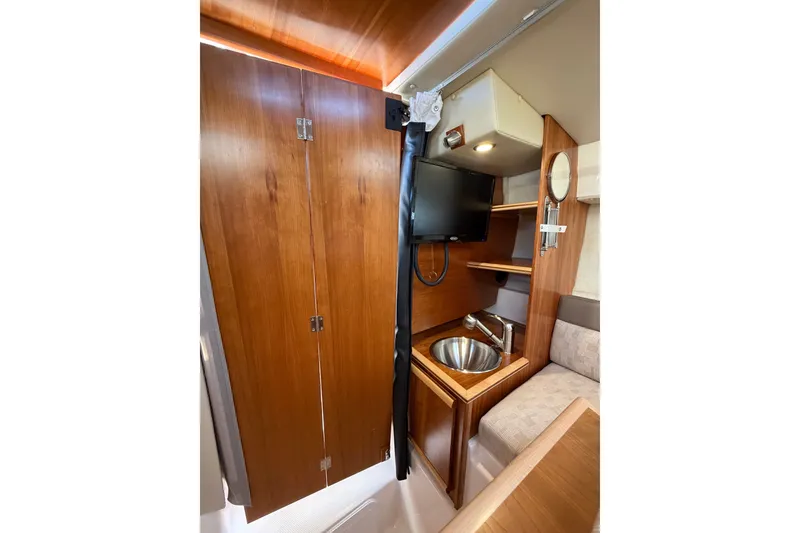 Slide: The Image of 2024 Cutwater C-248 Coupe interior with wood cabinetry, sink, and TV. - 21