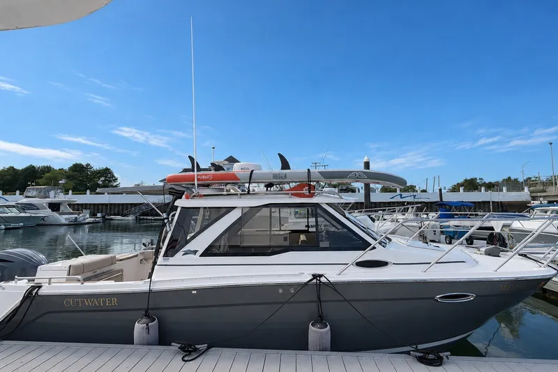 The Image of 2024 Cutwater C-248 Coupe boat docked at marina under clear blue sky. - 0