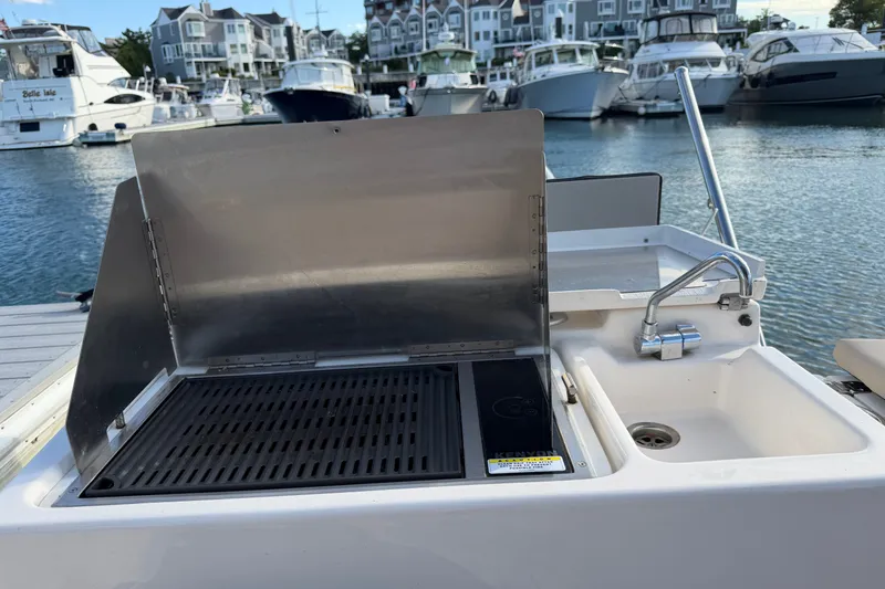 Slide: The Image of Outdoor kitchen on 2024 Cutwater C-248 Coupe boat, featuring grill and sink at marina. - 28