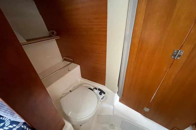 Slide: The Image of 2024 Cutwater C-248 Coupe bathroom with wooden cabinetry and compact toilet. - 23