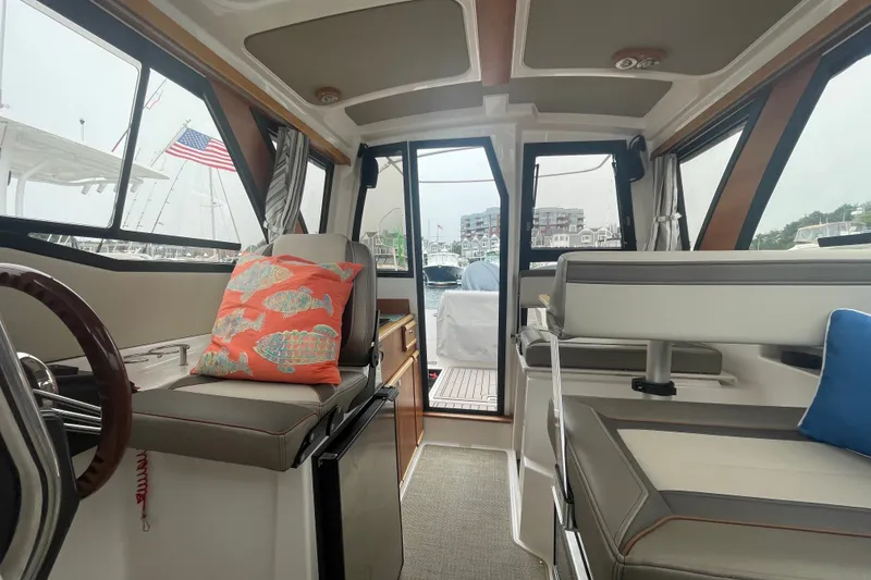 Slide: The Image of 2024 Cutwater C-248 Coupe interior with seating, colorful cushions, and marina view. - 20
