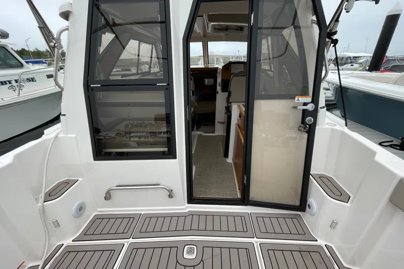 Slide: The Image of 2024 Cutwater C-248 Coupe boat interior view with open cabin door at marina. - 8
