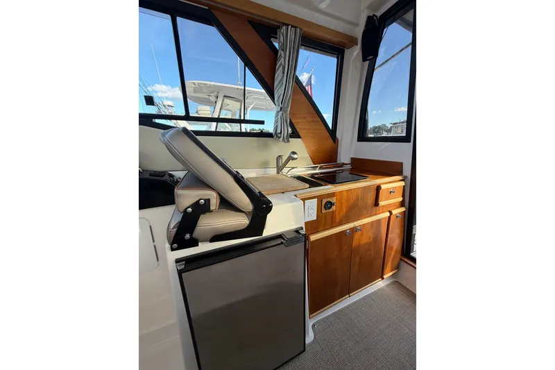 Slide: The Image of Interior of 2024 Cutwater C-248 Coupe featuring kitchenette and seating area. - 13