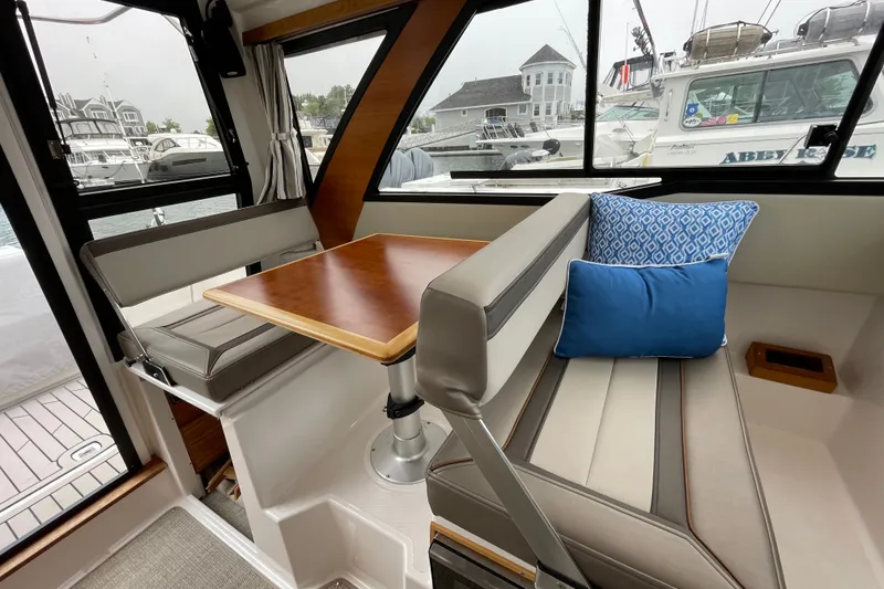 Slide: The Image of Interior of 2024 Cutwater C-248 Coupe with dining area and blue accent pillows. - 15
