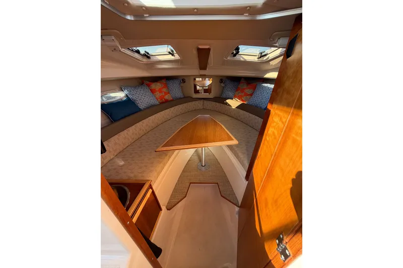 Slide: The Image of 2024 Cutwater C-248 Coupe interior with cozy seating and decorative cushions. - 17