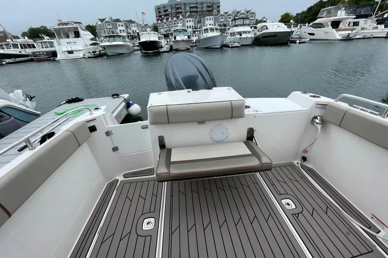Slide: The Image of 2024 Cutwater C-248 Coupe boat interior with docked yachts in the background. - 6