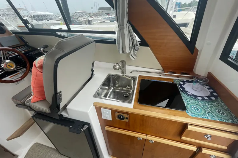 Slide: The Image of 2024 Cutwater C-248 Coupe interior with helm, sink, and kitchenette area. - 11