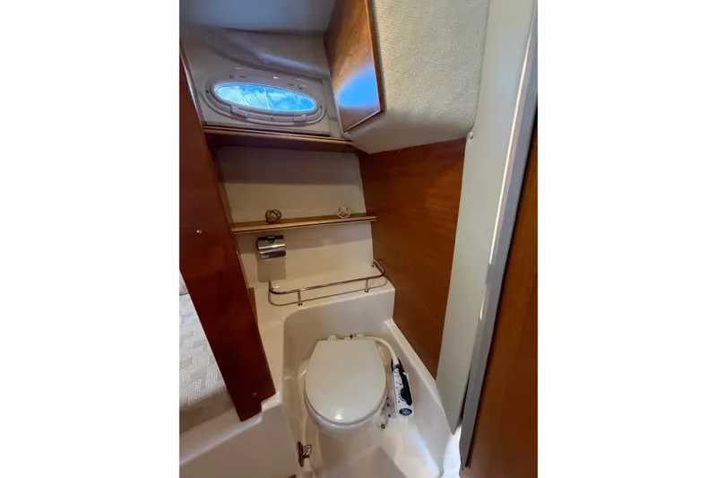 Slide: The Image of 2024 Cutwater C-248 Coupe bathroom with compact toilet and wooden cabinetry. - 22