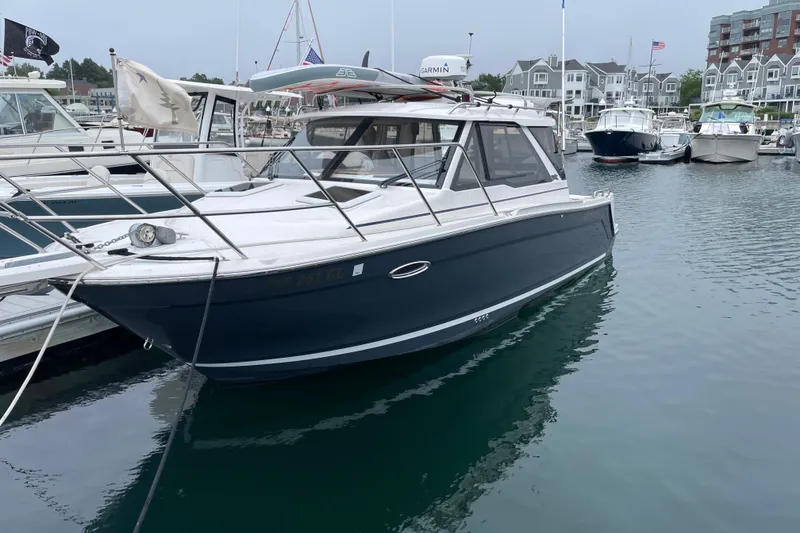 The Image of 2024 Cutwater C-248 Coupe docked in a marina, surrounded by other boats. - 0