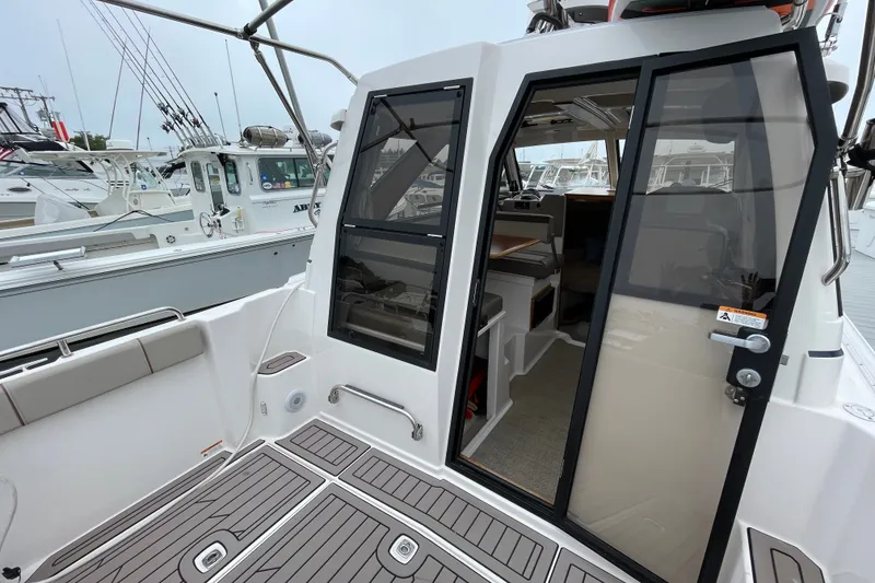 Slide: The Image of 2024 Cutwater C-248 Coupe boat interior with open door, docked at marina. - 9