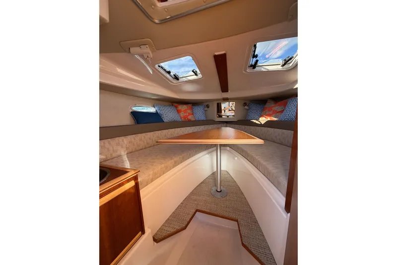 Slide: The Image of 2024 Cutwater C-248 Coupe interior with cozy seating and wooden table. - 18