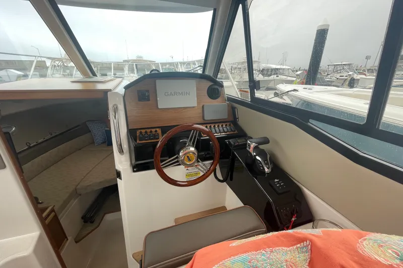 Slide: The Image of 2024 Cutwater C-248 Coupe interior with Garmin navigation system and cozy seating area. - 13