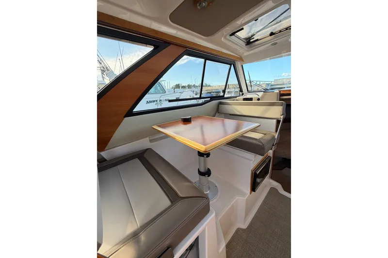 Slide: The Image of Interior of 2024 Cutwater C-248 Coupe, featuring a sleek dining area with large windows. - 23