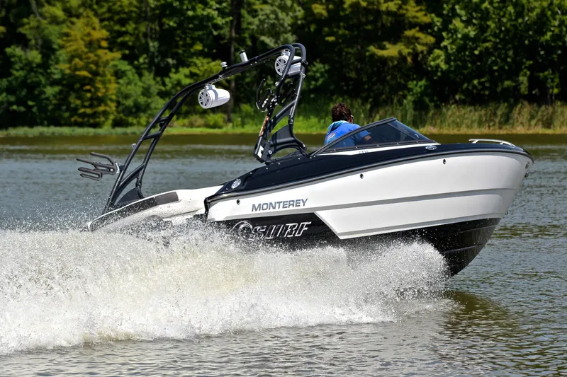 Slide: The Image of 2020 Monterey 218 Surf boat cruising on a lake with lush green trees in the background. - 4