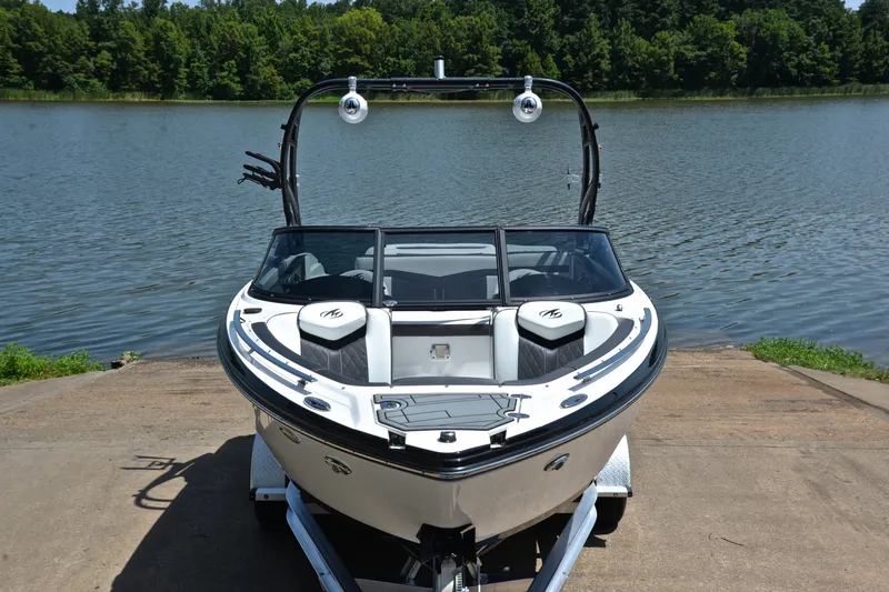 Slide: The Image of 2020 Monterey 218 Surf boat on trailer by a lake, surrounded by trees. - 17