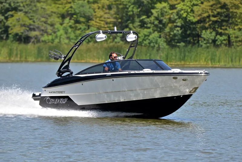 The Image of 2020 Monterey 218 Surf boat cruising on a lake with lush greenery in the background. - 1