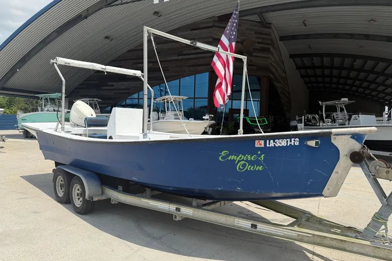 Slide: The Image of 2006 Reno Skiff 23ft boat on trailer with American flag, labeled "Empire's Own." - 2