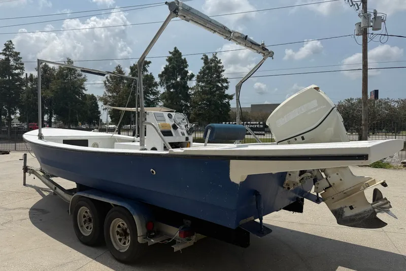 Slide: The Image of 2006 Reno Skiff 23ft boat on trailer with outboard motor, parked outdoors. - 4