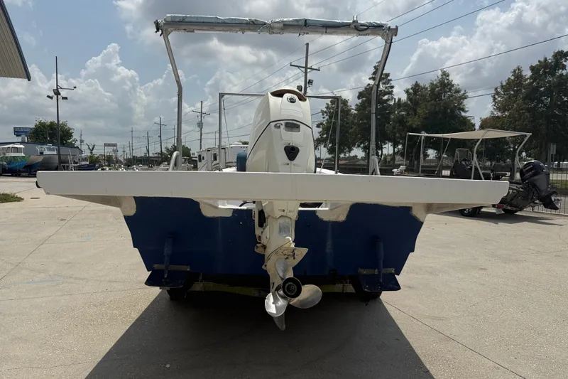 Slide: The Image of 2006 Reno Skiff 23ft boat with outboard motor, parked outdoors on a sunny day. - 5
