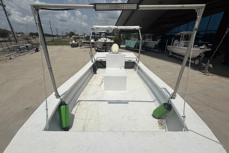 Slide: The Image of 2006 Reno Skiff 23ft boat on display at a marina, featuring open deck design. - 10