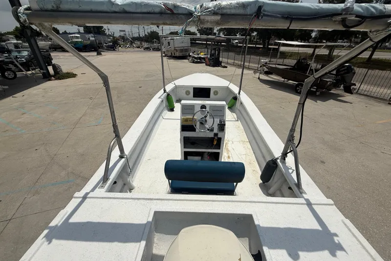 Slide: The Image of 2006 Reno Skiff 23ft boat interior with steering console, parked in a marina. - 7