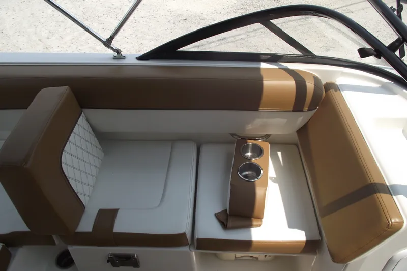 Slide: The Image of 2020 Bayliner DX 2000 boat interior with brown and white seating and cup holders. - 7