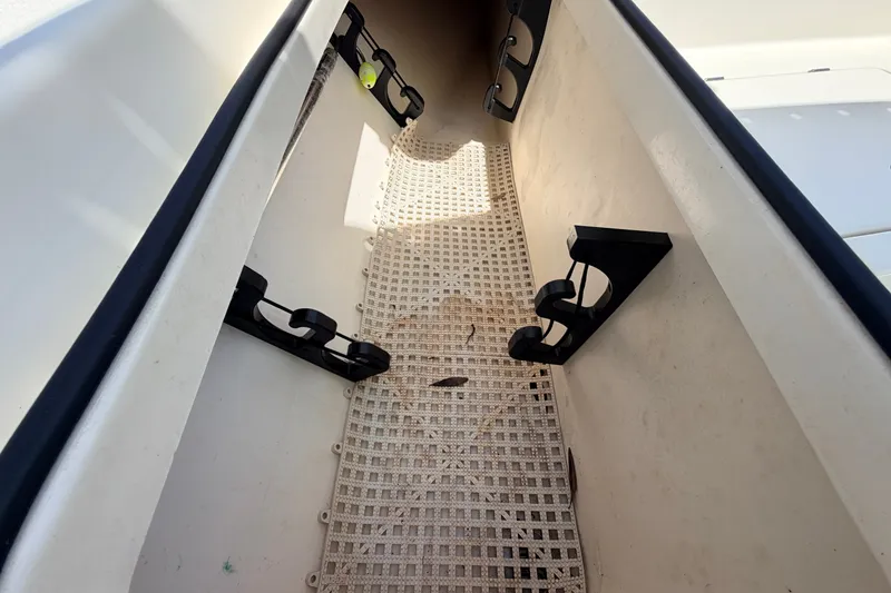 Slide: The Image of Storage compartment in a 2013 Pathfinder 2300 HPS boat with rod holders and mat. - 74