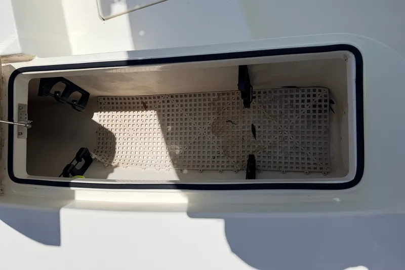 Slide: The Image of Open storage compartment on 2013 Pathfinder 2300 HPS boat, featuring a grid floor. - 73