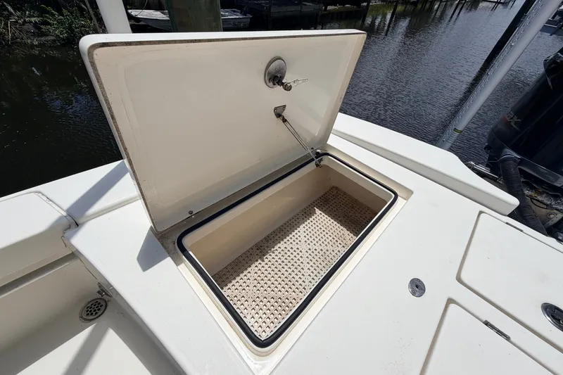 Slide: The Image of Open storage compartment on a 2015 Pathfinder 2300 HPS boat, near water. - 17