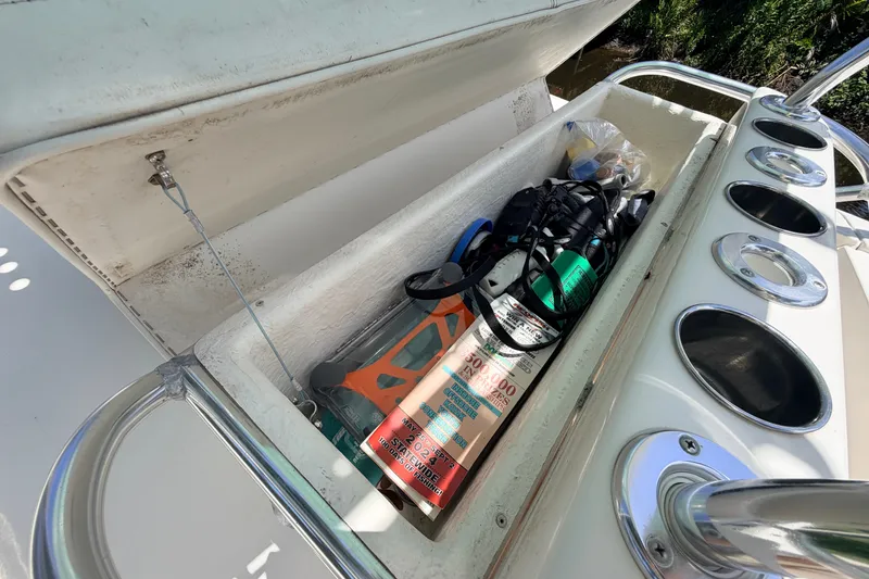 Slide: The Image of Open storage compartment on 2015 Pathfinder 2300 HPS boat with various gear inside. - 32