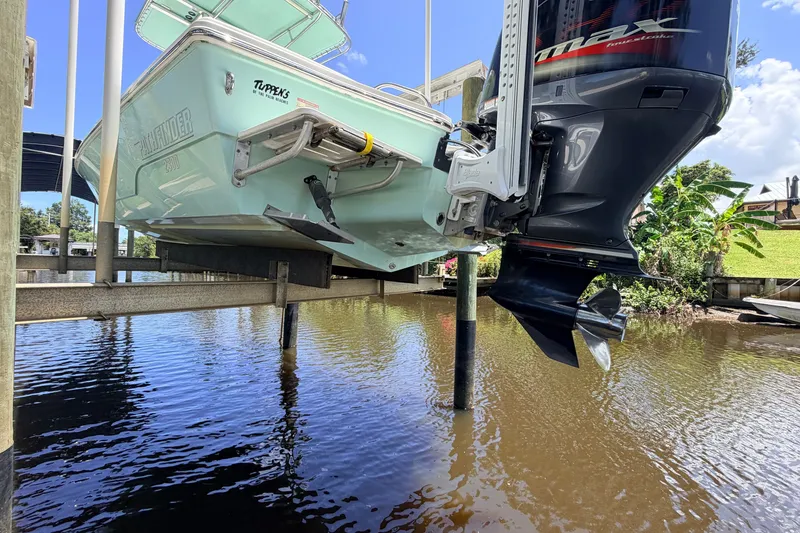 Slide: The Image of 2015 Pathfinder 2300 HPS boat on lift, showcasing outboard motor and hull design. - 4
