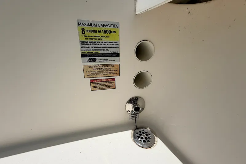 Slide: The Image of 2015 Pathfinder 2300 HPS boat capacity and safety labels with drain and water inlet. - 13