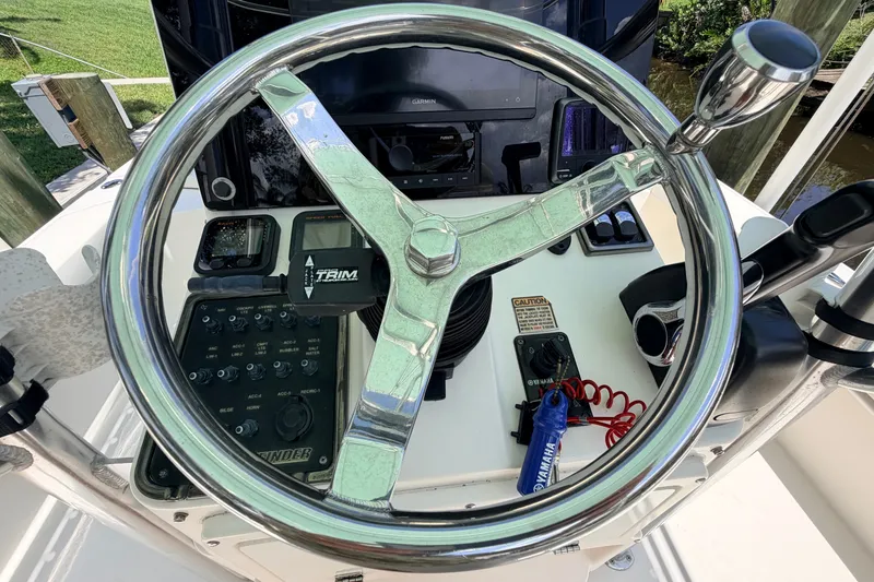 Slide: The Image of Steering wheel and controls of a 2013 Pathfinder 2300 HPS boat. - 49