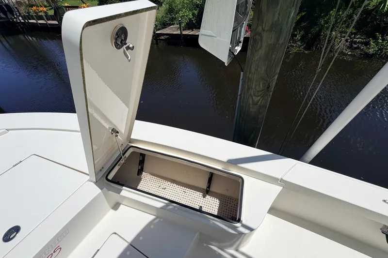 Slide: The Image of Open storage compartment on 2013 Pathfinder 2300 HPS boat by a dock. - 76
