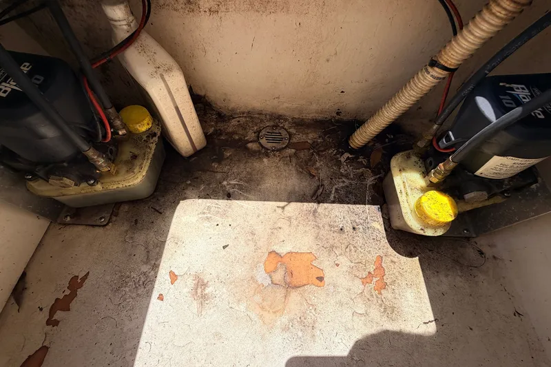 Slide: The Image of 2015 Pathfinder 2300 HPS bilge area with pumps and wiring, showing wear and dirt. - 27