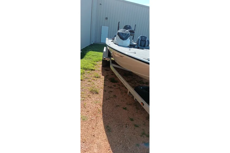 Slide: The Image of 2025 Ranger ALPHA 208 boat parked on gravel beside a building. - 18