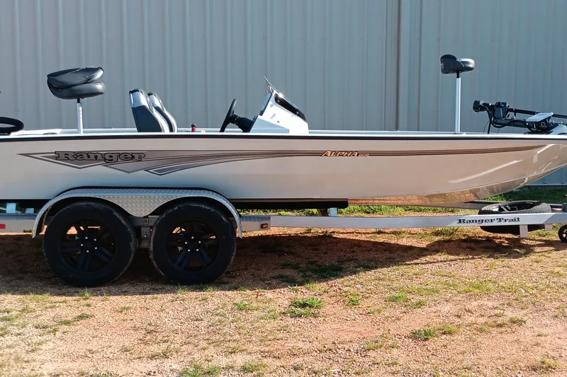 Slide: The Image of 2025 Ranger ALPHA 208 boat on trailer, side view, parked outdoors. - 1